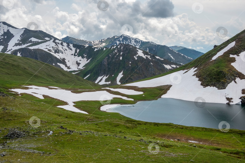 Скачать Яркий зеленый пейзаж с красивым альпийским озером. фотосток Ozero