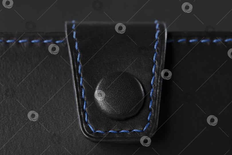 Скачать Черное кожаное изделие крупным планом на черном фоне. фотосток Ozero