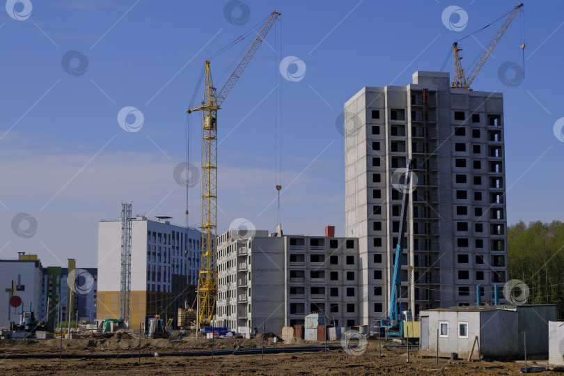 Скачать Башенные краны на стройке жилых многоквартирных домов. Строительство нового квартала. фотосток Ozero
