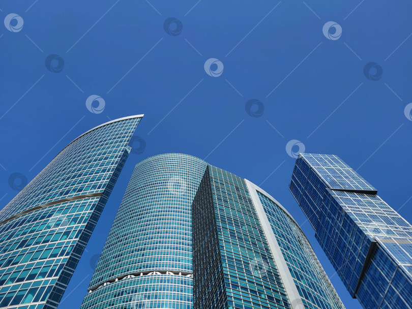 Скачать Москва, Россия, 09:10 2024 г. На фоне современной архитектуры. Небоскребы "Федерация" в деловом районе Москва-Сити возвышаются на фоне голубого неба фотосток Ozero