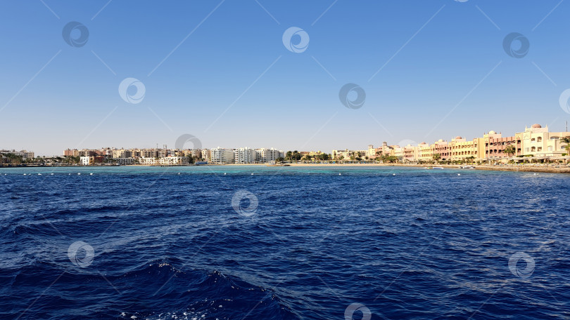 Скачать Яркое побережье с чистой голубой водой и песчаным пляжем, красочными зданиями и безмятежной атмосферой, идеально подходящее для отдыха. Красное море. Хургада. Египет фотосток Ozero