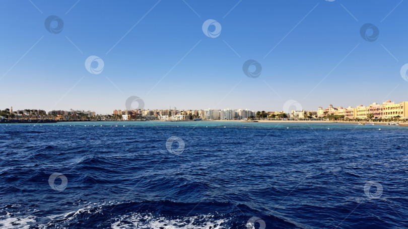 Скачать Живописный вид на побережье с яркими зданиями вдоль береговой линии, чистыми голубыми водами и ярким небом, передающий суть спокойной приморской атмосферы. Красное море. Хургада. Египет фотосток Ozero