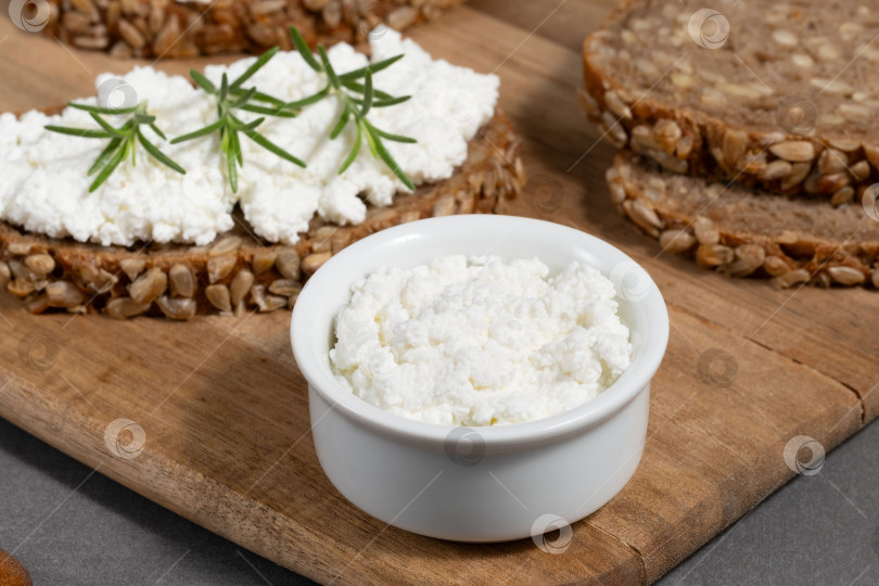 Скачать Вкусный ржаной хлеб со сливочным сыром и свежей зеленью на деревянной доске в деревенском стиле фотосток Ozero