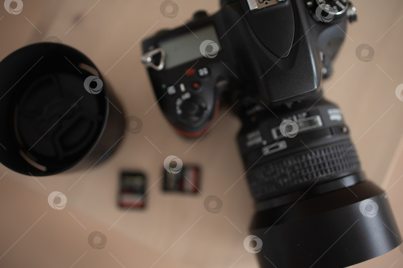Скачать Фотоаппарат с объективом и флэш-накопителями. коричневый фон фотосток Ozero