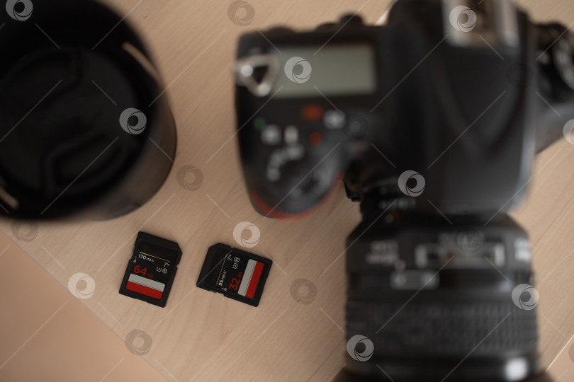 Скачать Фотоаппарат с объективом и флэш-накопителями. коричневый фон фотосток Ozero