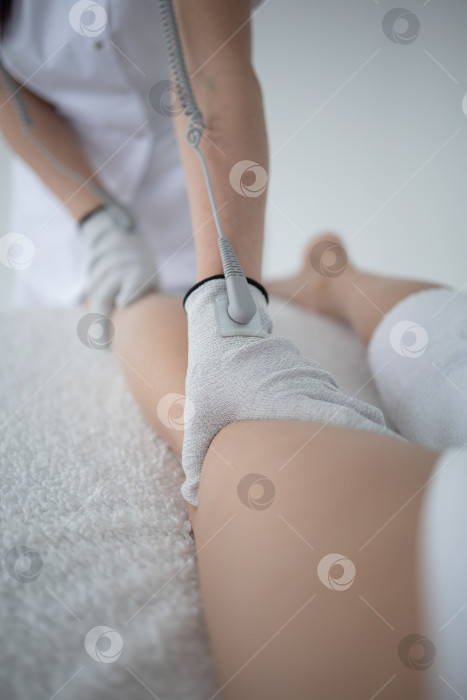 Скачать массажист массирует спину и лопатки молодой женщине, лежащей на массажном столе на белом фоне. Концепция массажных спа-процедур. фотосток Ozero