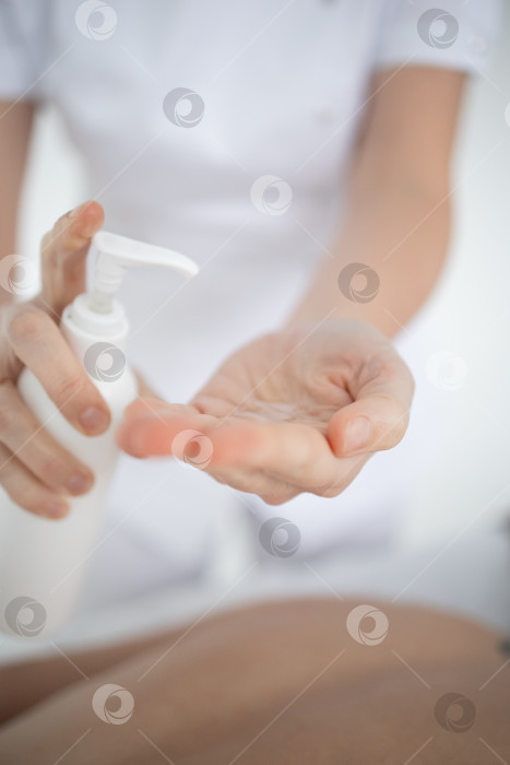 Скачать Крупным планом руки массажиста, наносящие ароматическое масло на спину женщины. Массажистка готовится к проведению восточной спа-процедуры для расслабления. Массажист делает женщине массаж с ароматерапевтическим маслом. фотосток Ozero