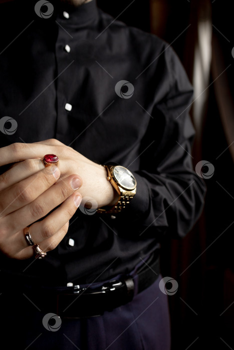 Скачать Мужчина в черной рубашке. Крупный план рук и мужских украшений фотосток Ozero