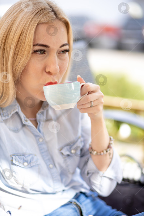Скачать Молодая женщина пьет из белой чашки фотосток Ozero