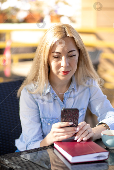 Скачать Молодая женщина сидит летом в кафе на террасе фотосток Ozero