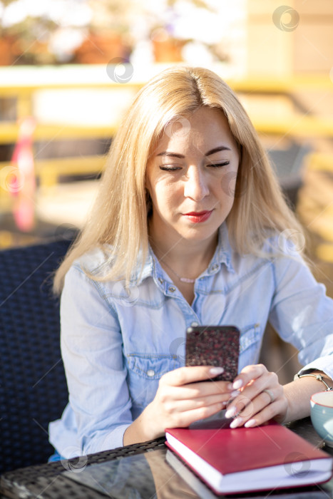 Скачать Молодая женщина сидит летом в кафе на террасе фотосток Ozero