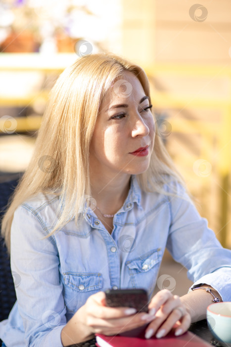 Скачать Молодая женщина сидит летом в кафе на террасе фотосток Ozero