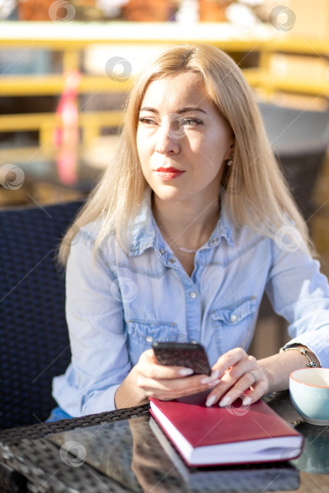 Скачать Молодая женщина сидит летом в кафе на террасе фотосток Ozero