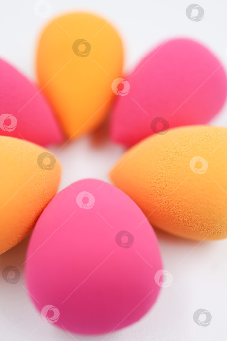 Скачать розовые и оранжевые косметические губки на фоне светлого дерева, крупным планом фотосток Ozero