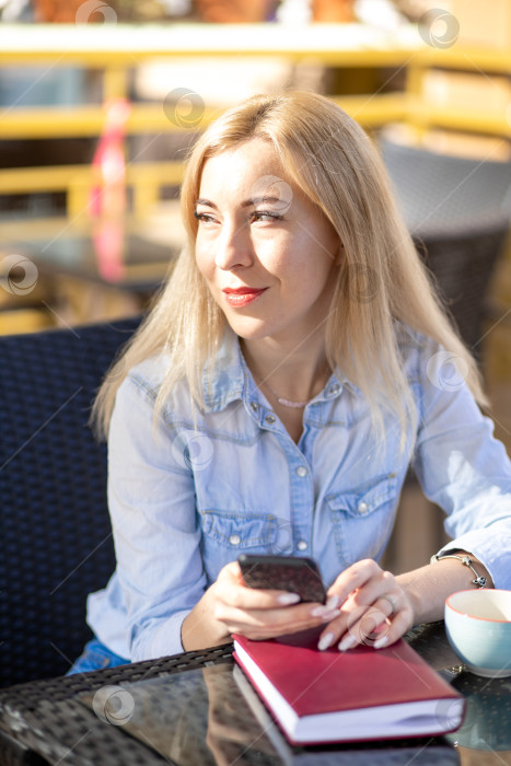 Скачать Молодая женщина сидит летом в кафе на террасе фотосток Ozero