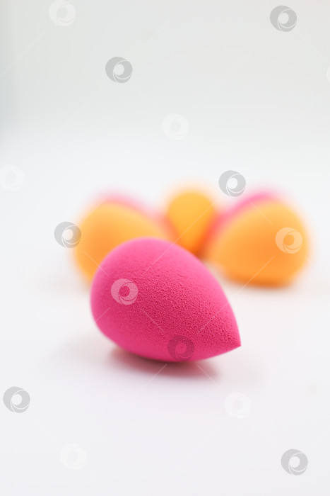 Скачать розовые и оранжевые косметические губки на фоне светлого дерева, крупным планом фотосток Ozero