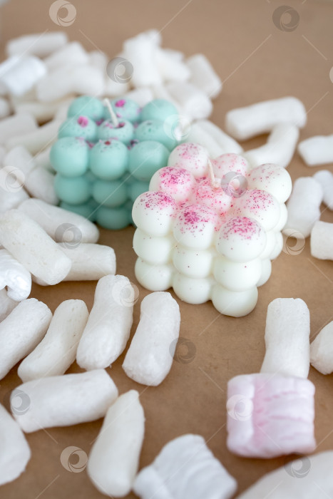 Скачать Две свечи из кокосового или соевого воска на столе с воздушным зефиром. Фотография на монохромном фоне фотосток Ozero