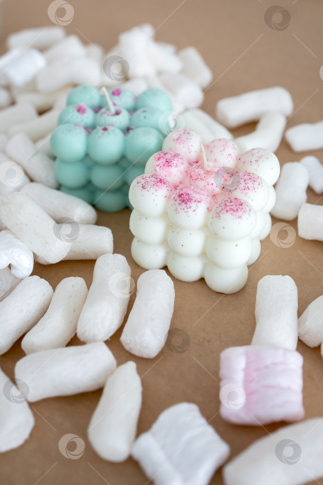 Скачать Две свечи из кокосового или соевого воска на столе с воздушным зефиром. Фотография на монохромном фоне фотосток Ozero