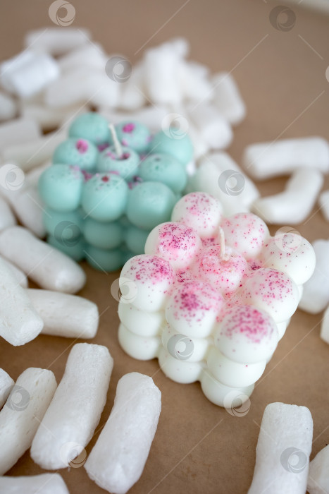 Скачать Две свечи из кокосового или соевого воска на столе с воздушным зефиром. Фотография на монохромном фоне фотосток Ozero