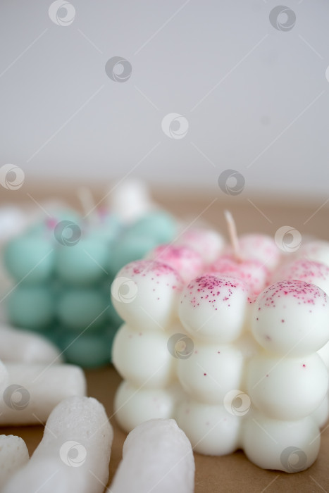 Скачать Две свечи из кокосового или соевого воска на столе с воздушным зефиром. Фотография на монохромном фоне фотосток Ozero