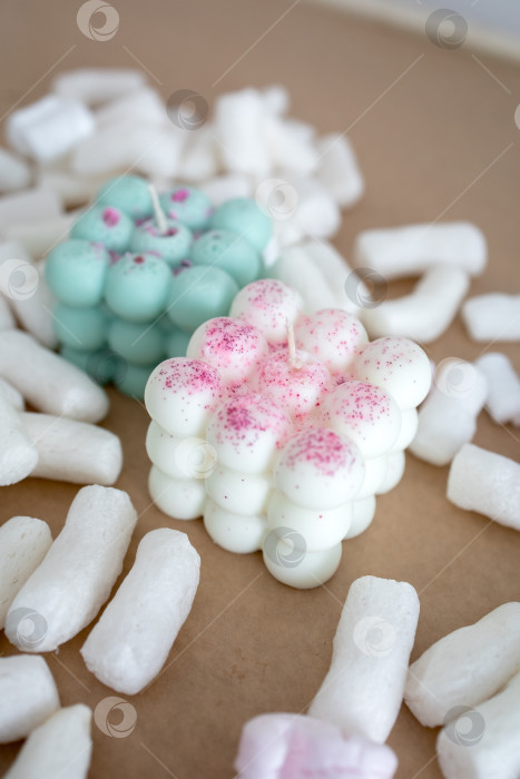 Скачать Две свечи из кокосового или соевого воска на столе с воздушным зефиром. Фотография на монохромном фоне фотосток Ozero