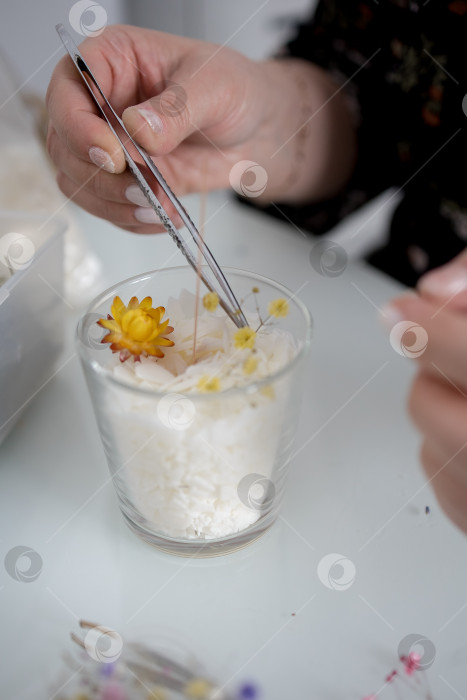 Скачать украшение в виде свечи в банке, изготовление свечей. Свеча, сделанная руками женщины. Плоская форма, вид сверху. Синий фон фотосток Ozero