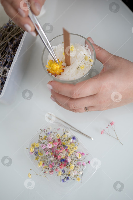 Скачать украшение в виде свечи в банке, изготовление свечей. Свеча, сделанная руками женщины. Плоская форма, вид сверху. Синий фон фотосток Ozero