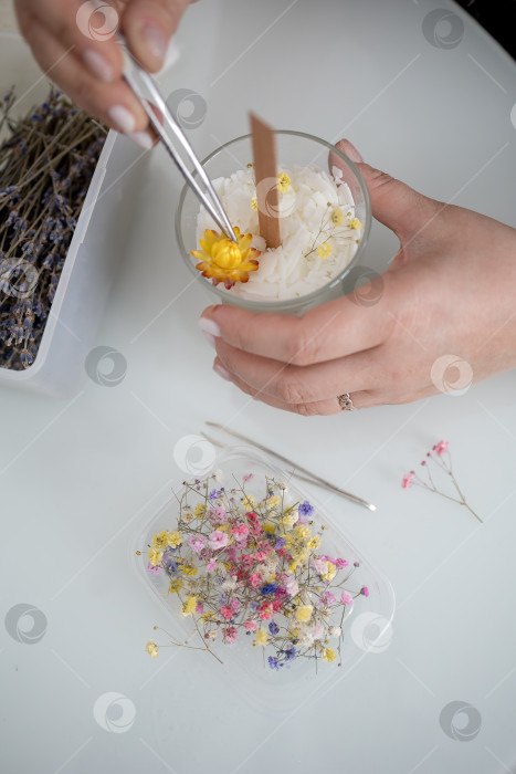 Скачать украшение в виде свечи в банке, изготовление свечей. Свеча, сделанная руками женщины. Плоская форма, вид сверху. Синий фон фотосток Ozero