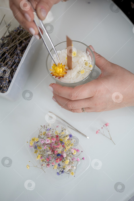 Скачать украшение в виде свечи в банке, изготовление свечей. Свеча, сделанная руками женщины. Плоская форма, вид сверху. Синий фон фотосток Ozero