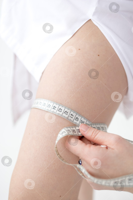Скачать Женщина измеряет размер своих бедер рулеткой фотосток Ozero