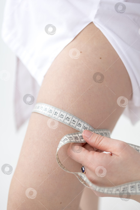 Скачать Женщина измеряет размер своих бедер рулеткой фотосток Ozero