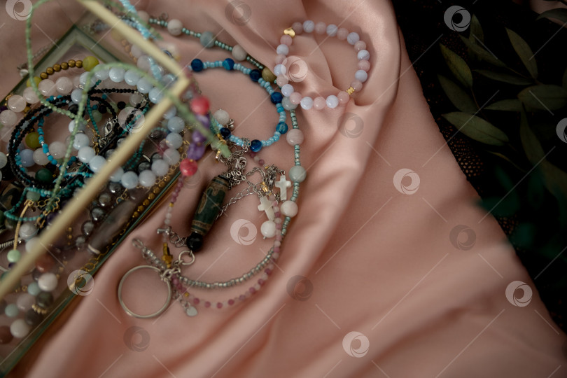 Скачать Концепция богатства и удачи. Браслет с черными счастливыми камнями на белом фоне. фотосток Ozero