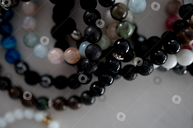 Скачать Концепция богатства и удачи. Браслет с черными счастливыми камнями на белом фоне. фотосток Ozero