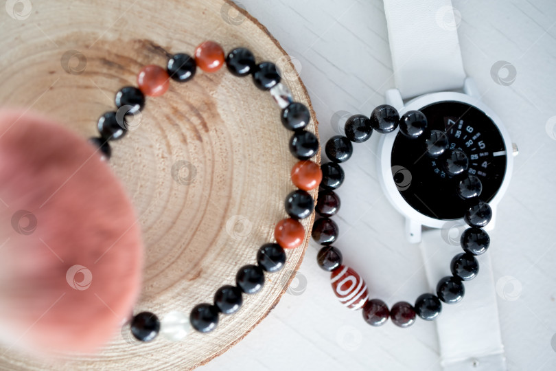 Скачать Концепция богатства и удачи. Браслет с черными счастливыми камнями на белом фоне. фотосток Ozero