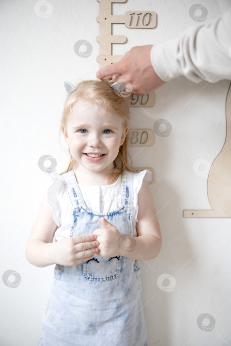 Скачать Маленькая девочка измеряет рост с помощью ростомера фотосток Ozero