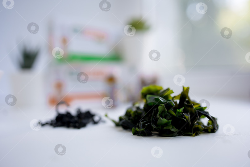 Скачать сушеные водоросли на белом фоне. сушеная морская капуста ламинария или бурые водоросли ламинариум.конбу, водоросли вакаме. крупный план фотосток Ozero