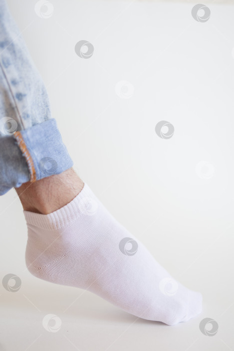 Скачать Мужская нога в белом носке на белом фоне. Мужская нога в носке. фотосток Ozero