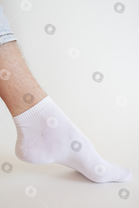 Скачать Мужская нога в белом носке на белом фоне. Мужская нога в носке. фотосток Ozero