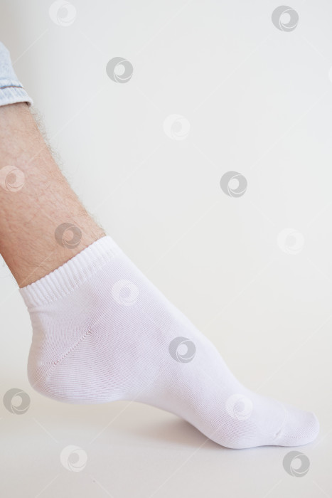 Скачать Мужская нога в белом носке на белом фоне. Мужская нога в носке. фотосток Ozero