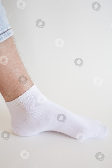 Скачать Мужская нога в белом носке на белом фоне. Мужская нога в носке. фотосток Ozero