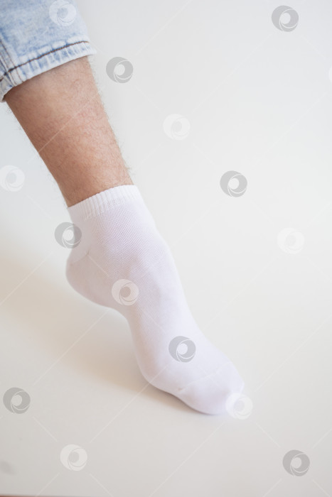 Скачать Мужская нога в белом носке на белом фоне. Мужская нога в носке. фотосток Ozero