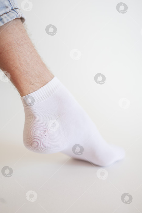 Скачать Мужская нога в белом носке на белом фоне. Мужская нога в носке. фотосток Ozero