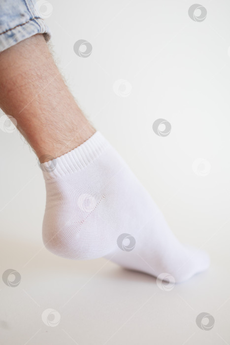 Скачать Мужская нога в белом носке на белом фоне. Мужская нога в носке. фотосток Ozero