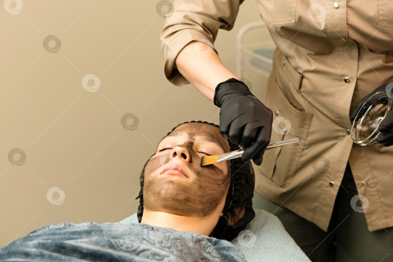 Скачать Косметолог наносит углеродный наногель на лицо клиента фотосток Ozero
