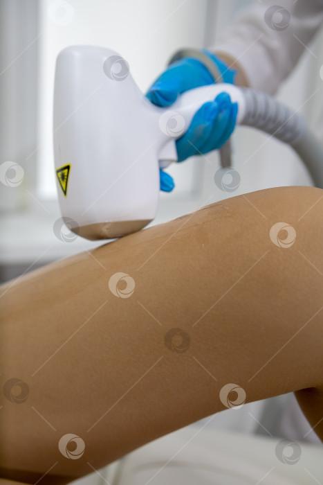 Скачать Процедура удаления волос. На кадре молодая подтянутая клиентка, проходящая процедуру лазерной эпиляции тела в клинике красоты. Концепция женской красоты и косметологии фотосток Ozero