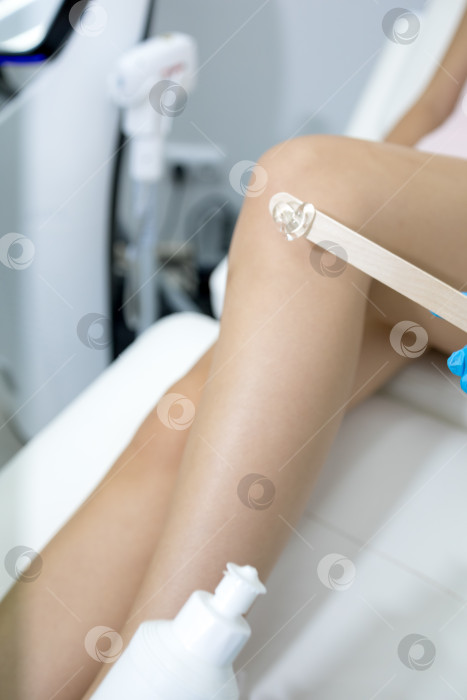 Скачать Процедура удаления волос. На кадре молодая подтянутая клиентка, проходящая процедуру лазерной эпиляции тела в клинике красоты. Концепция женской красоты и косметологии фотосток Ozero