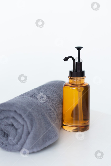 Скачать Флакон органического косметического масла.МАСЛО для массажа во флаконе с дозатором и полотенцем на белом фоне фотосток Ozero