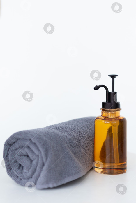 Скачать Флакон органического косметического масла.МАСЛО для массажа во флаконе с дозатором и полотенцем на белом фоне фотосток Ozero