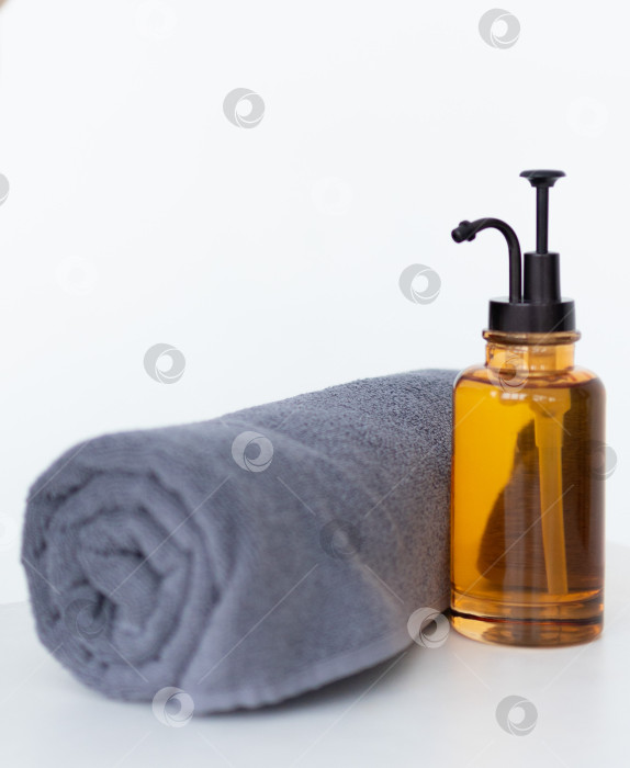 Скачать Флакон органического косметического масла.МАСЛО для массажа во флаконе с дозатором и полотенцем на белом фоне фотосток Ozero