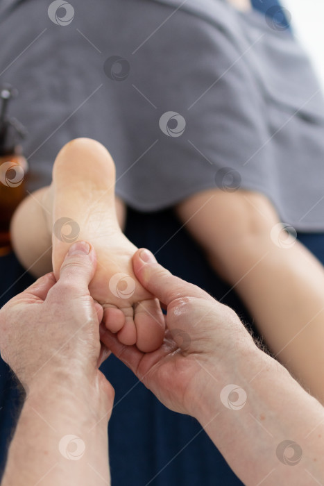 Скачать Массаж для детских стоп. женские руки делают массаж стоп ребенку фотосток Ozero